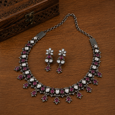 Oxidized jewellery necklace and matching earrings displayed on a wooden background